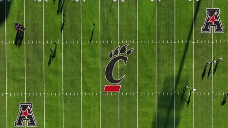 Aerial-view-above-a-american-football-training-inside-the-Nippert-Stadium,-at-the-University-of-Cincinnati,-USA---cenital,-drone-shot