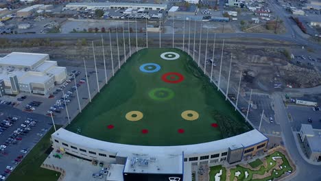 Aerial-view-moving-from-the-front-entrance-toward-the-back-of-the-new-Top-Golf-in-Vinyard-Utah-during-dusk