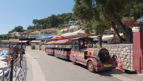 Paar-Zu-Fuß-Entlang-Der-Promenade,-Vorbei-An-Einem-Touristischen-Straßenzug,-Parga,-Griechenland