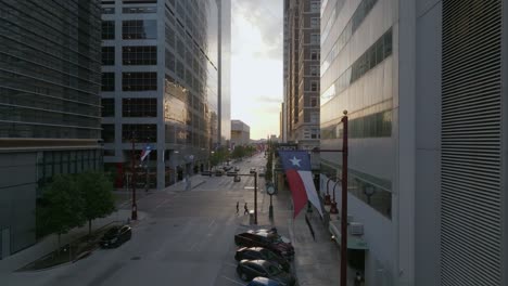 Luftbild-Auf-Straßenebene-Von-Geparkten-Autos-Und-Einer-Flagge-Auf-Der-Texas-Avenue-In-Houston-City---Aufsteigen,-Zurückziehen,-Drohnenschuss