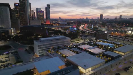 Aerial-view-over-the-urban-rooftop-park-and-sustainable-organic-farm-on-top-of-the-POST-Houston-Cultural-center,-dusk-in-Texas,-USA