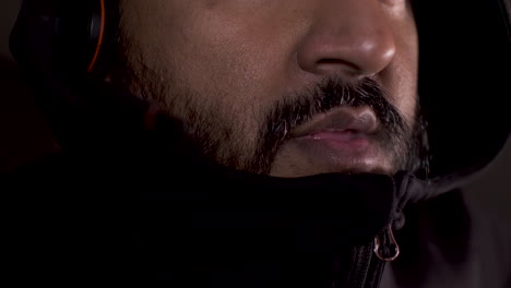 Close-Up-Of-Adult-Bearded-Indian-Male-With-Hoodie-Pulled-Up-To-Chin-Talking