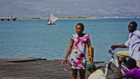 Segelboot-An-Der-Küste-Von-Haiti-Mit-Ureinwohnern-Im-Vordergrund