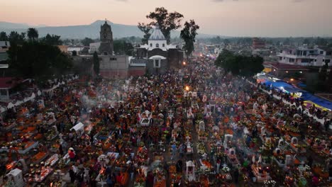 Flying-over-smoking-tombstones,-decorated-in-to-honor-the-dead,-Dia-de-los-Muertos-in-Mexico---aerial-view