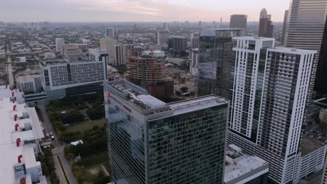 Aerial-view-over-the-Marriot-hotel,-towards-the-Skanska´s-new-office-tower-construction-site,-sunrise-in-Houston,-USA