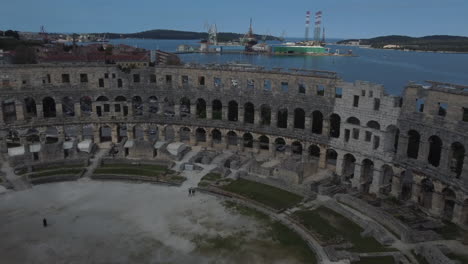Drone-shot-of-the-Amphitheater-in-Pula,-Croatia---drone-is-flying-across-the-ancient-Roman-site