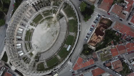 Drone-shot-of-the-Amphitheater-in-Pula,-Croatia---drone-is-ascending-straight-over-the-Roman-site