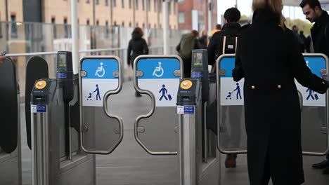 La-Gente-Usa-La-Puerta-De-Acceso-Para-Entrar-A-La-Estación-En-Londres,-Reino-Unido