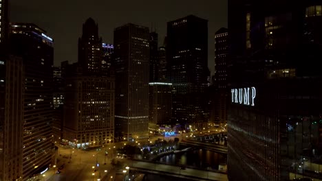 Chicago,-Illinois-Downtown-District-Bei-Nacht---Aufsteigende-Luftaufnahme-Mit-Trump-Hotel-Und-Tower-Im-Vordergrund