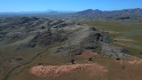 Drone-shot-of-the-Namib-Naukluft-National-Park-in-Namibia---drone-is-reversing-over-the-green-steppe-landscape