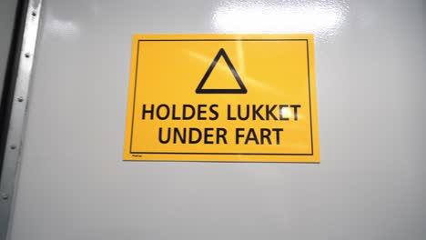 Sign-on-watertight-door-in-ships-engine-room-warning-that-door-should-always-be-closed-at-sea---Approaching-big-yellow-sign-with-Norwegian-language