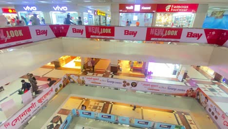 Pan-Left-Shot-Across-Shopping-Mall-Floors-With-Shoppers-Walking-Past-In-Dhaka