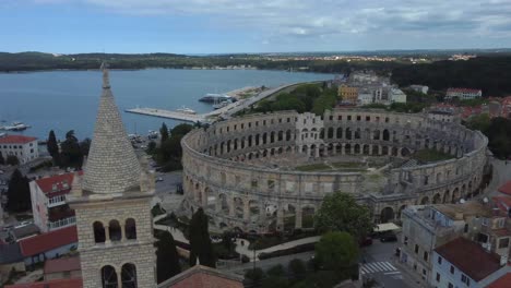 Drone-shot-of-the-Amphitheater-in-Pula,-Croatia---drone-is-passing-by-a-nearby-church