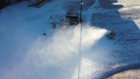Snow-cannon-blows-artificial-snow-onto-ski-run-at-Myrkdalen-ski-resort-in-Norway---Aerial-with-beautiful-sunset-light