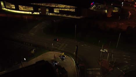 Night-flying-over-McDonalds-drive-through-aerial-view-orbiting-to-illuminated-highway-tilt-down-Birdseye
