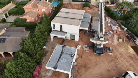 Construction-site-of-almost-finished-modular-building-home,-aerial-circling