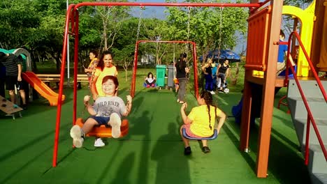 Mother-Swinging-Her-Little-Cute-Child-In-Public-Park-In-Playground,-Asuncion,-Paraguay
