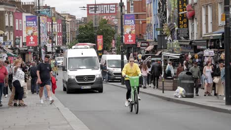 Camden-High-Street-by-Camden-Town-Market-full-of-people,-cars,-cyclist
