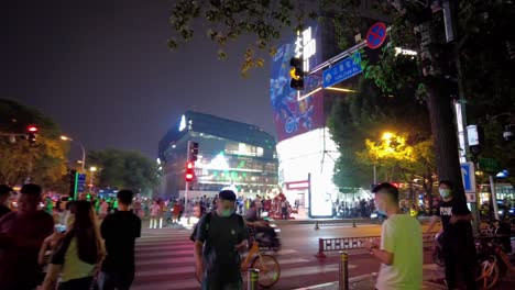 Beijing-Sanlitun-Taikooli,-Sanlitun-Road-at-night-with-people-walking-around,-Beijing-night-life