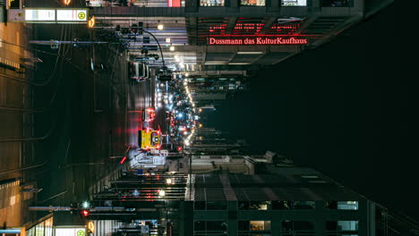 VERTICAL-busy-city-centre-avenue-Friedrichstrasse-illuminated-at-night-in-Berlin-time-lapse
