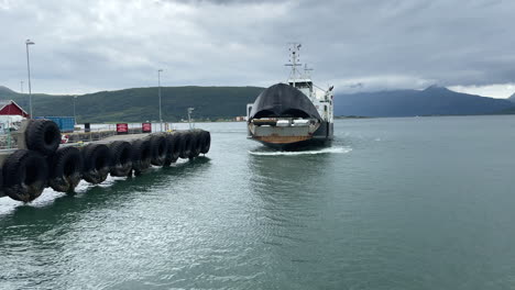 Medium-static-shot-of-a-car-ferry-opening-its-bow-as-it-pulls-into-port-on-a-cloudy-day-in-Nesna-Norway