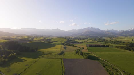 Resplandor-Del-Atardecer-Iluminando-Campos-Y-Montañas-En-Nueva-Zelanda