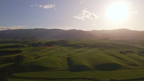 Vuelo-De-Drones-Hacia-El-Sol-Poniente-Sobre-Suaves-Colinas-En-Las-Estribaciones-De-Los-Alpes-Del-Sur-De-Nueva-Zelanda