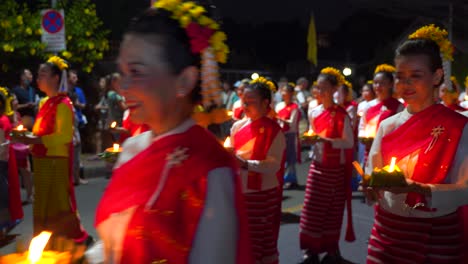 Frauen-In-Traditionellen-Thailändischen-Kleidern,-Die-Während-Der-Yi-Peng-parade-Mit-Kerzen-Spazieren-Gehen