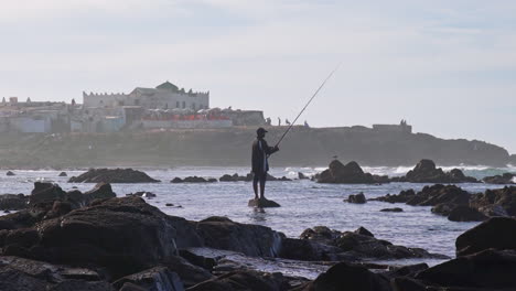 Man-fishing-by-the-ocean-in-front-of-Sidi-Abderrahman-island-in-Casablanca-Morocco
