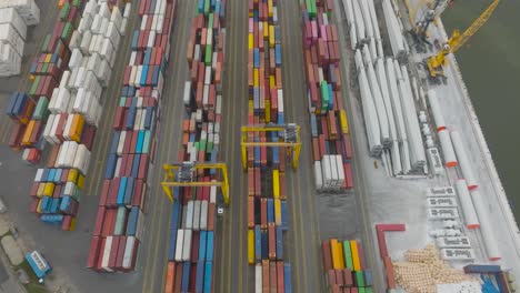 Eine-Luftaufnahme-Des-Containerterminals-Im-Hafen-Zeigt-Reihen-Von-Containern-Mit-Waren,-Die-Darauf-Warten,-Auf-Schiffe-Verladen-Zu-Werden