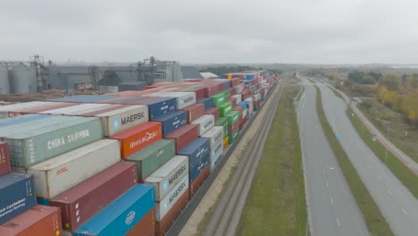 aerial-view-of-many-empty-metal,-rusted,-and-colored-sea-containers-lined-up-in-a-port-terminal