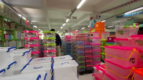 A-consumer-is-browsing-through-an-array-of-neatly-arranged-plastic-boxes-of-food-or-utensils-in-a-variety-of-colors