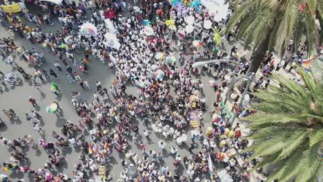 Aerial-flyover-of-Gay-Pride-Day-crowd-celebrating-on-city-street,-MX