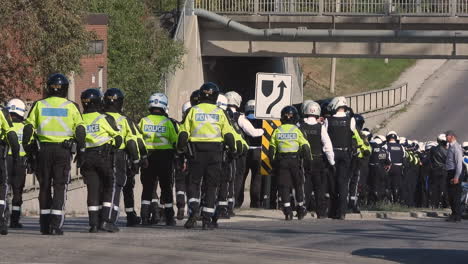 Long-procession-line-of-motorcycle-police-officers-gathering-at-motorway-underpass,-Ontario,-Canada