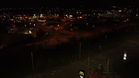 McDonalds-fast-food-drive-through-logo-illuminated-at-night-next-to-Northern-UK-town-highway