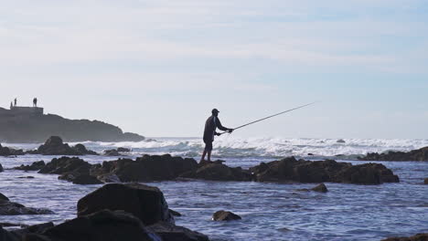 Hombre-Pescando-Frente-A-La-Isla-De-Sidi-Abderrahman-En-La-Playa-De-Ain-Diab,-Casablanca,-Marruecos
