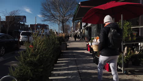 Exterior-wide-establishing-shot-of-Danforth-Avenue-with-Xmas-trees-for-sale-at-a-corner-store