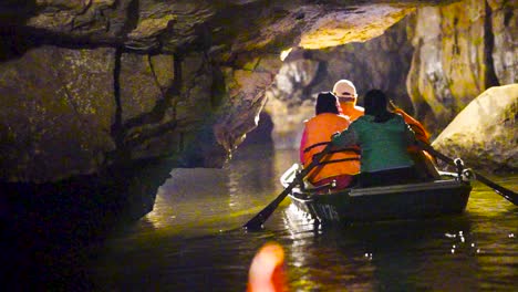 Turistas-En-Tour-Guiado-En-Bote-En-Cuevas-En-Ninh-Binh,-Vietnam