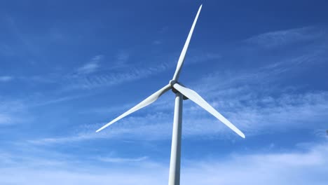Einzelne-Windkraftanlage-Dreht-Sich-Mit-Wenigen-Wolken-Dahinter