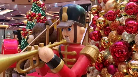 Red-nutcracker-soldier-with-trumpet-surrounded-by-Christmas-tree-and-Christmas-balls