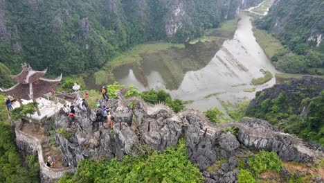 Aerial-360-Overhead-View-Of-Tourists-Walking-Along-Hang-Mua-To-Viewpoint-Summit
