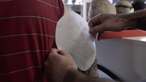 Tattoo-preparation-with-paper-drawing-to-find-the-right-spot