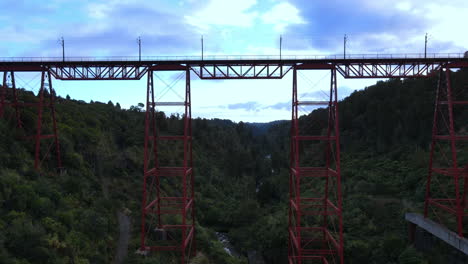 Ziehen-Sie-Die-Drohnenaufnahme-Der-Roten-Eisenbahnbrücke-über-George-Mit-Bäumen-Und-Fluss-Weg