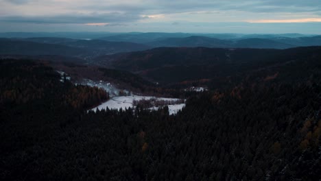 Luftaufnahmen-Von-Hügeliger-Landschaft,-Die-In-Der-Wintersaison-Mit-Schwarzwald-Bedeckt-Ist
