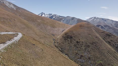 Berghang-Bedeckt-Mit-Trockenem-Büschelbusch-Und-Schneebedeckten-Alpen-Im-Hintergrund