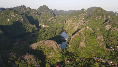 Aerial-Tilt-Up-View-Across-Sunrise-Light-Across-Ninh-Binh-Mountains-In-Vietnam