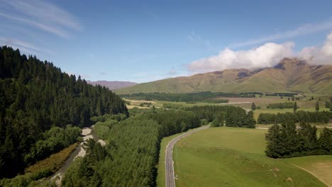 New-Zealand's-State-Highway-8-leading-through-farm-land-and-foothills-of-the-southern-alps-in-sunshine