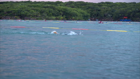 Cámara-Lenta-De-Atletas-Profesionales-Nadando-En-Una-Competencia-De-Triatlón-En-El-Mar