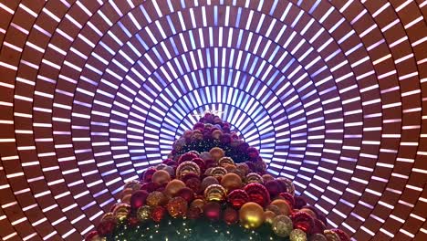 Static-shot-of-a-giant-christmas-tree,-with-modern-ceiling-lights-as-background