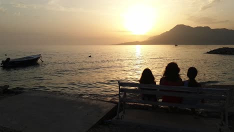 Silhouette-of-people-sitting-on-a-bench-against-the-sunset-over-the-Jadran-Sea